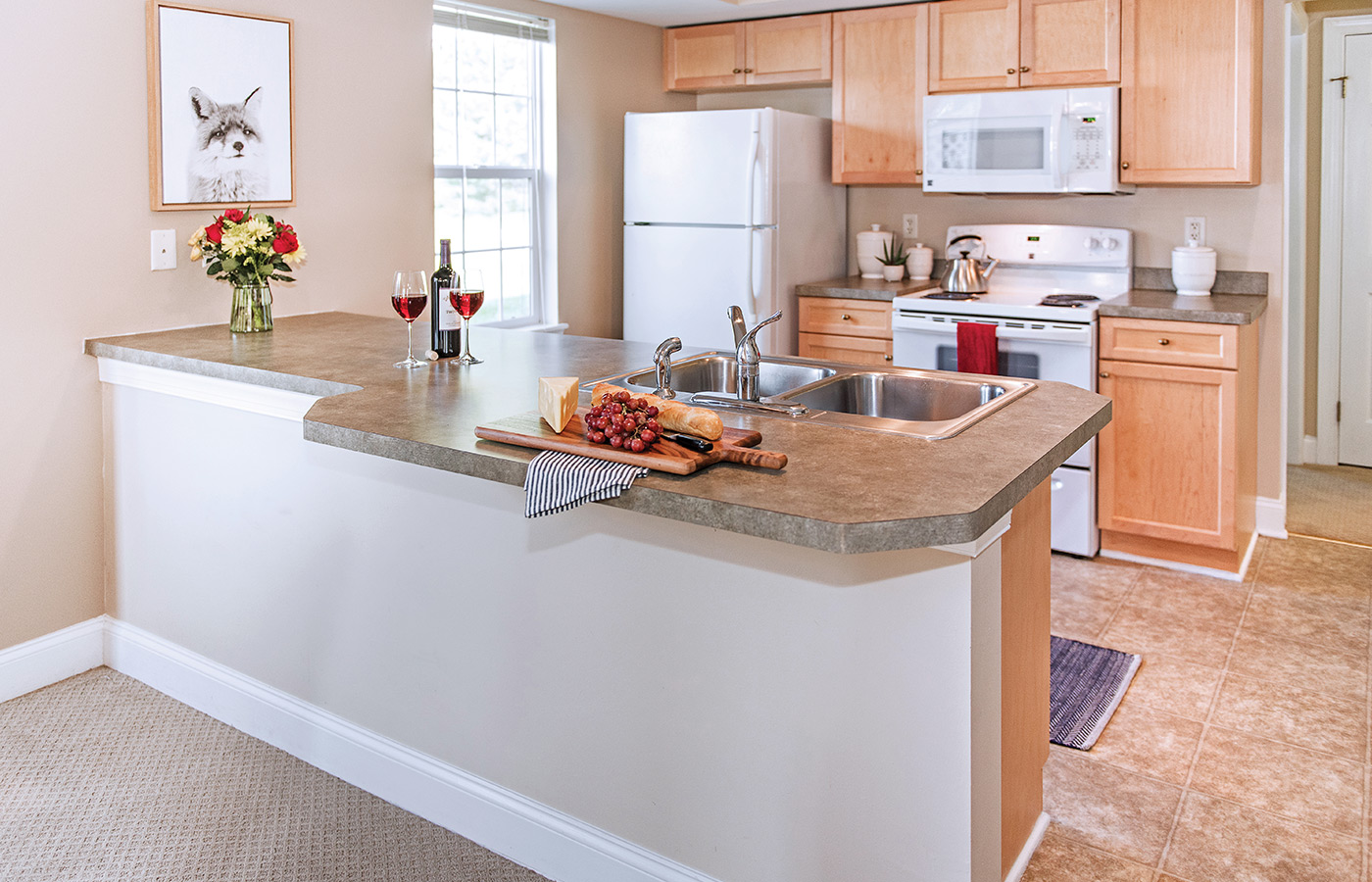 Furnished kitchen with table, cabinets, and refrigerator.