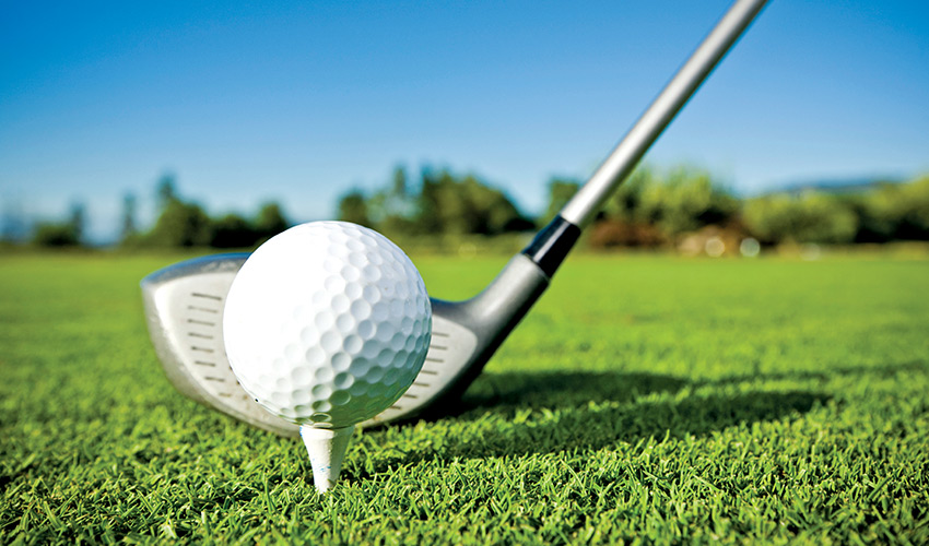 A club lined up with a golf ball.