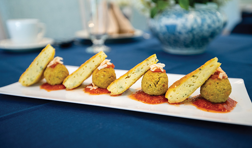 A plate of gourmet bites featuring meatballs and toast.