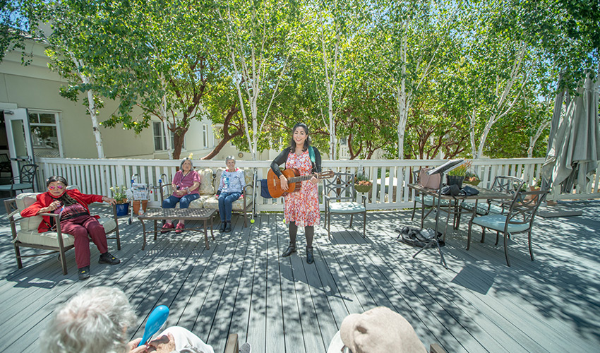 People listening to a person playing guitar.