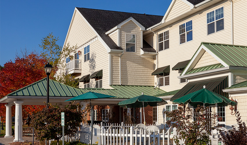 The exterior of a building with fall trees in the background.