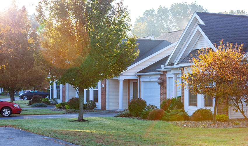 villa exterior at Legacy at Clover Clover in the sun with trees and a car