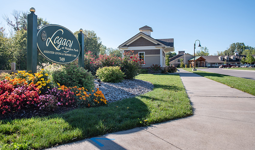 The exterior sign with flowers around it.