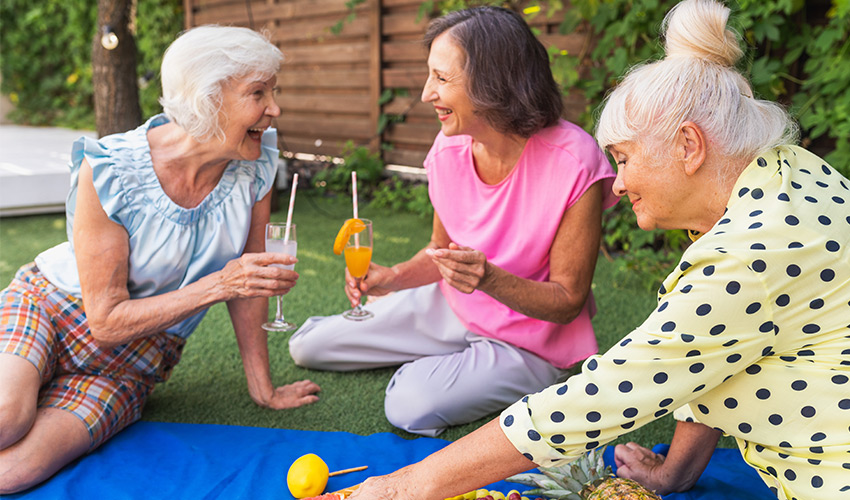 People sitting in the grass with drinks.