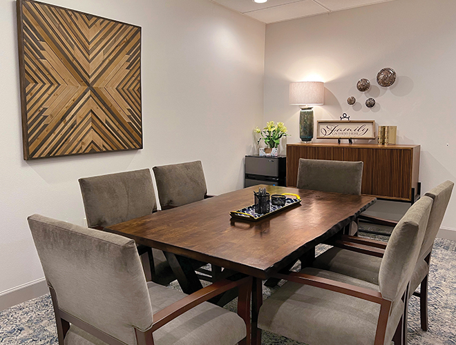 Dining table with chairs and art on wall.