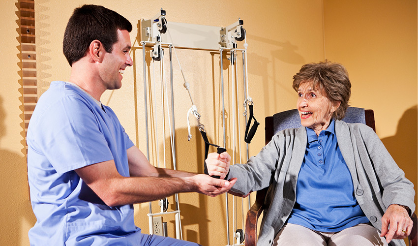 nurse helping patient with rehab exercises