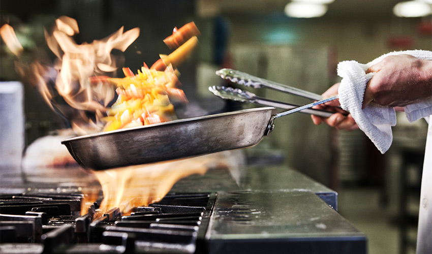 A pan with a fire over the stove.