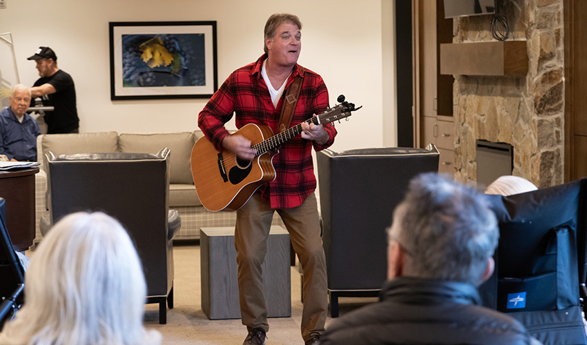 People watching a person play guitar.