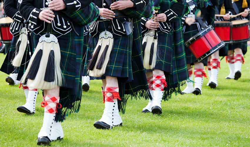 marching line with people playing bagpipes and drums