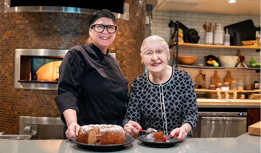 A resident and a chef in a kitchen.