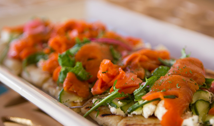 A plate of flat bread topped with fresh tomato and basil.