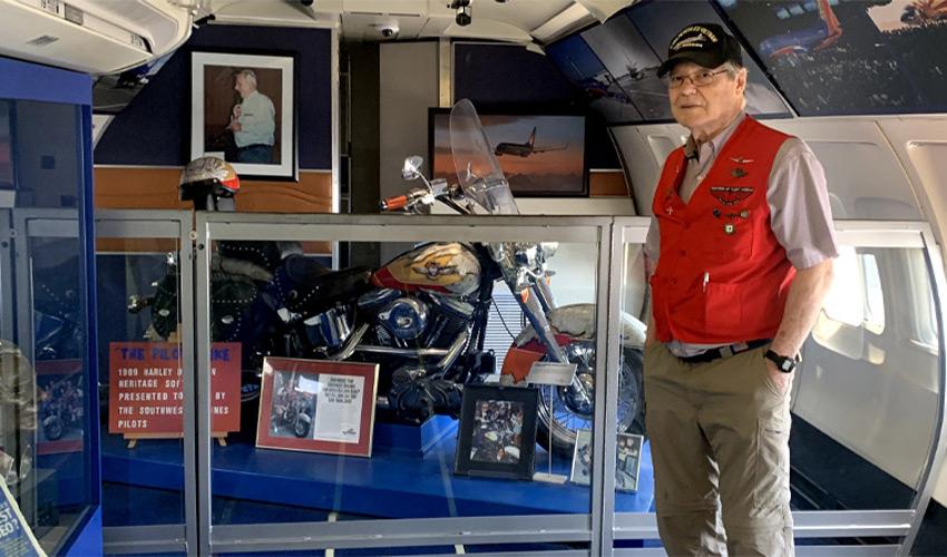 A person standing next to a motorcycle in a case.