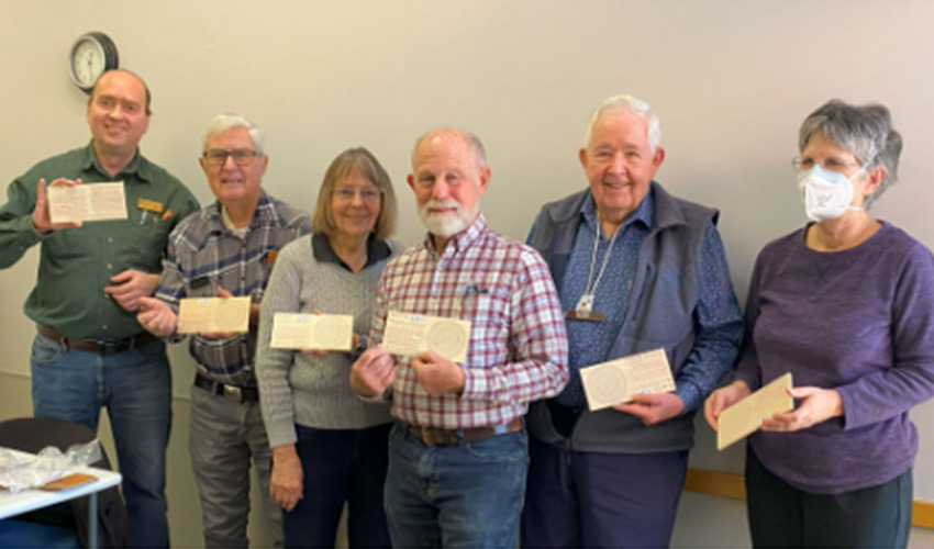 A group of people each holding a piece of paper.