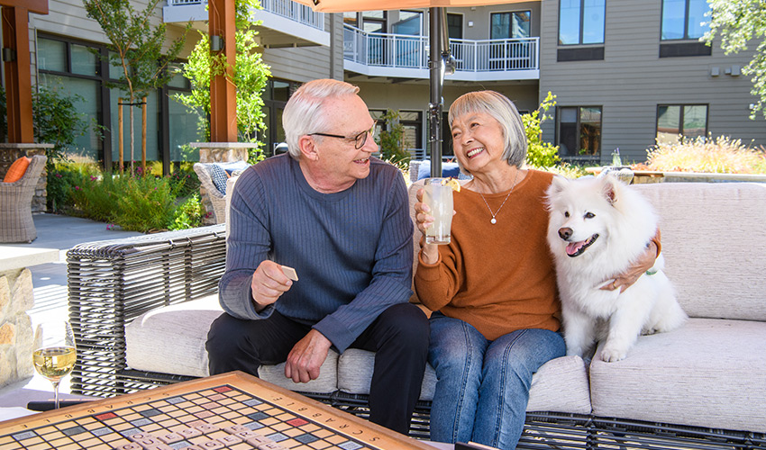 A couple on the patio with their dog.