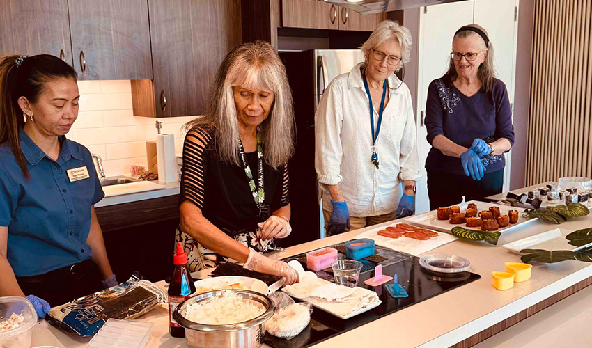 A group of people making sushi.