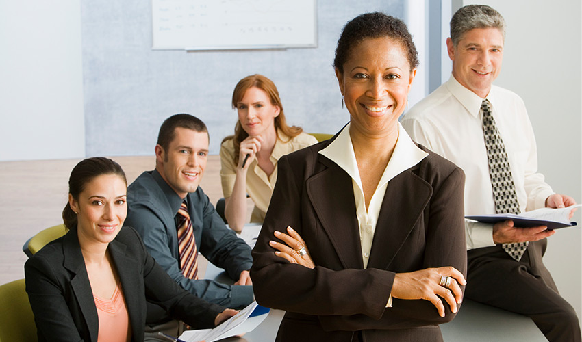 five people in business attire around a table