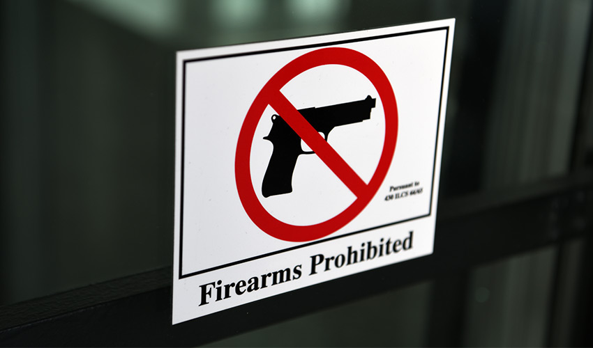 A sign on the door saying no firearms.