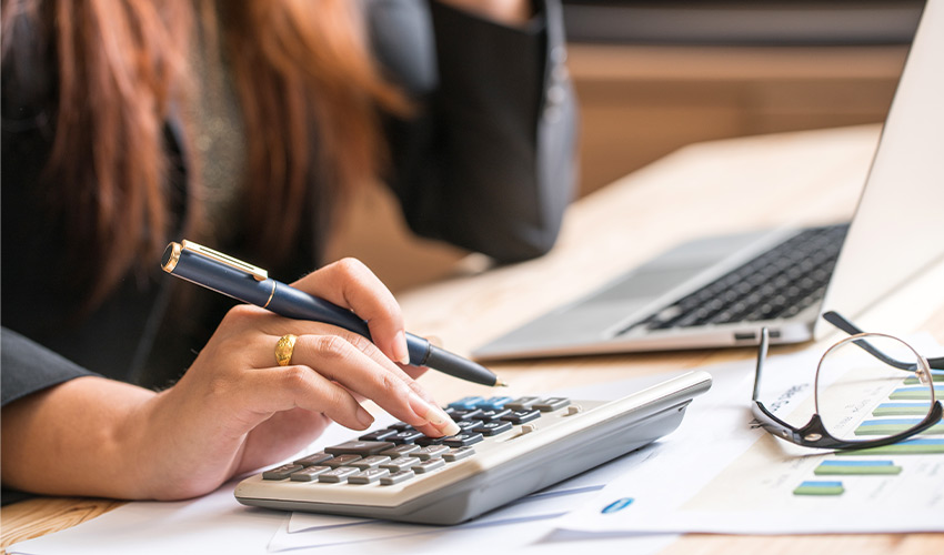 A person typing on a calculator.