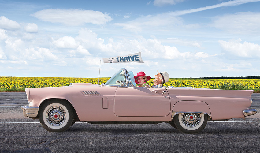 People driving in a pink convertable.