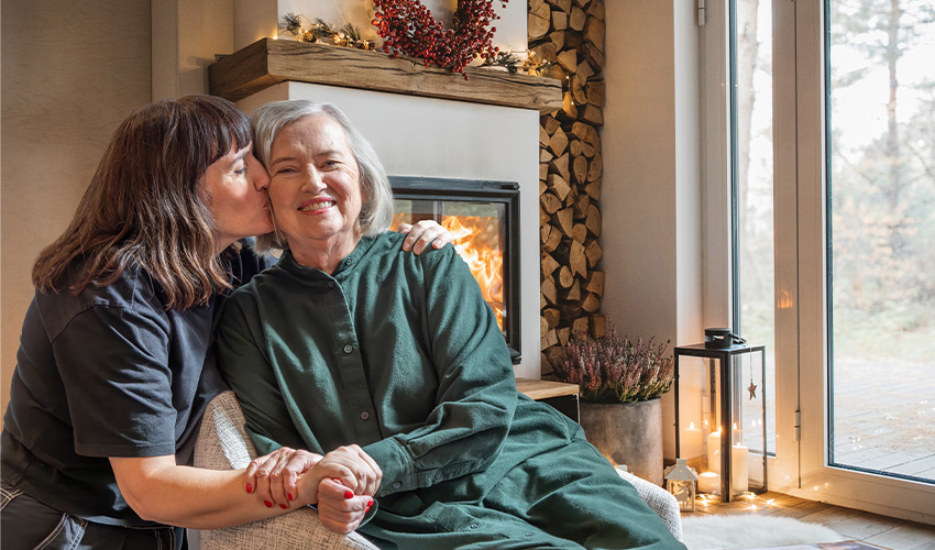 A person kissing their mother on the cheek.